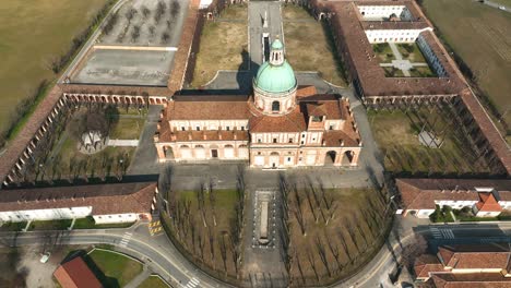 a stunning drone shot captures the lombardy sanctuary of caravaggio, with a breathtaking downwards tilting, up zooming out movement revealing the beautiful surroundings