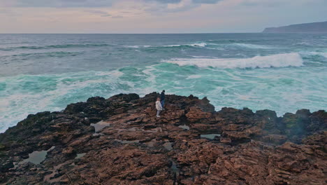 lonely woman standing ocean coast observing waves crash. explorer enjoy seascape