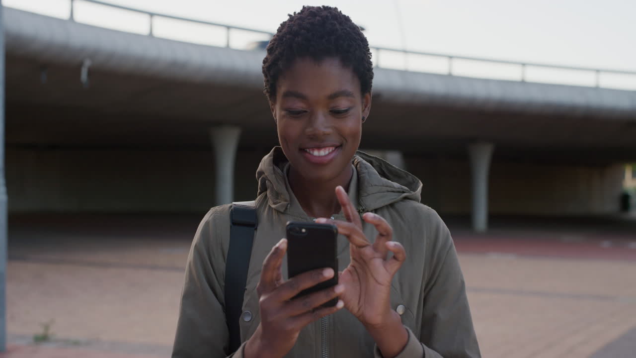 portrait young african american woman using smartphone texting browsing enjoying online communication on mobile phone slow motion