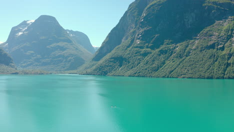 beautiful scenery of turquoise blue water of the lake amidst the green landscape of the mountains in stryn, norway