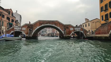 ponte dei tre archi bridge in cannaregio seen from sailing boat on canal, venice in italy