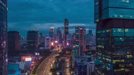 Aerial-dolly-hyperlapse-shot-of-busy-night-time-traffic-on-multi-lane-highway-through-modern-city-center-with-skyscrapers-in-Jakarta,-Motion-Time-Lapse-Hyper-Lapse