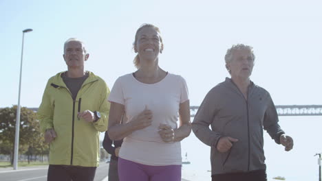 happy group of people jogging together outdoors