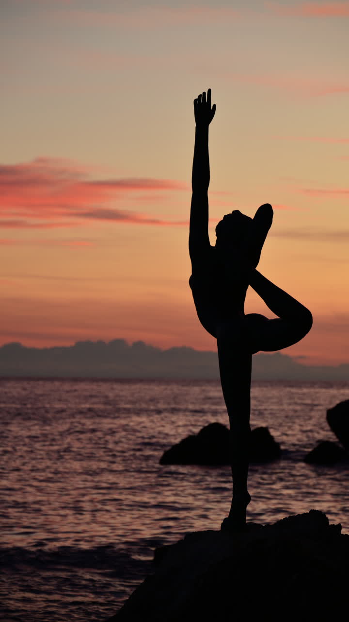 Statua in bronzo della ballerina che si erge in riva al mare a Budva, Montenegro, con il centro storico sullo sfondo.