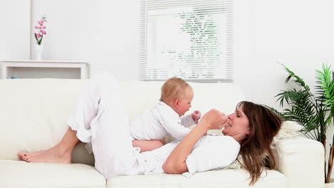 Baby-Sitzt-Auf-Einer-Frau-Und-Sie-Spielt-Mit-Ihm