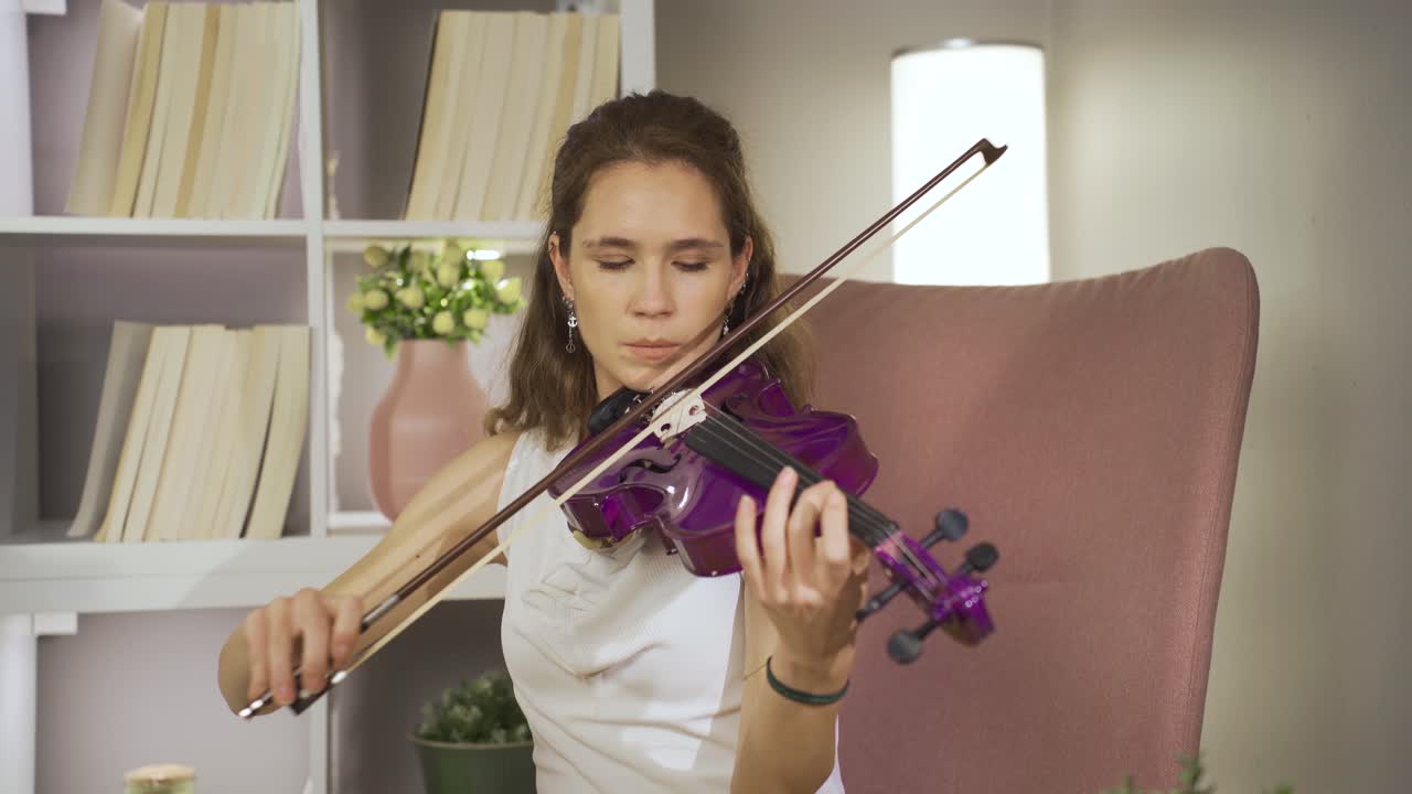 mujer músico tocando el violín sola en casa. música y partituras.