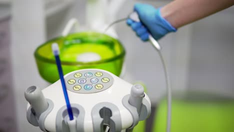 Dentists-hands-take-the-medical-tools-and-pouring-water-out-at-dental-clinic.-Close-up.-Concept-of-healthy-life