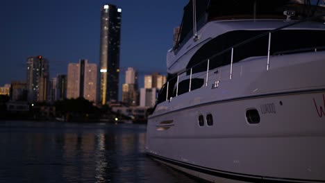 yacht docked with city skyline at night