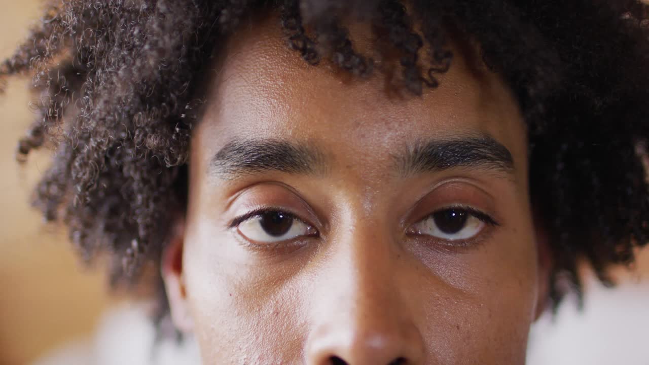 Portrait d'un homme afro-américain heureux regardant la caméra dans un chalet en bois rond, au ralenti