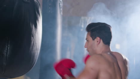 strong male boxer hitting punching bag with force