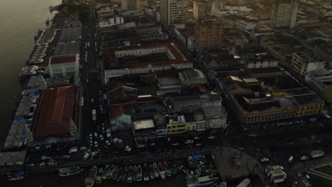 a slow tilting up aerial drone shot of the ver-o-peso market in belém, brazil at sunrise.