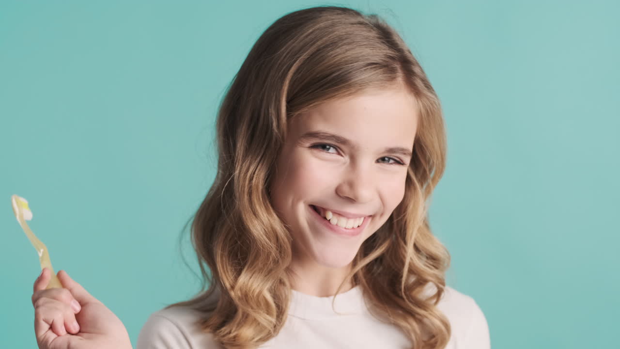 подростковая белая девушка в пижаме чистит зубы.