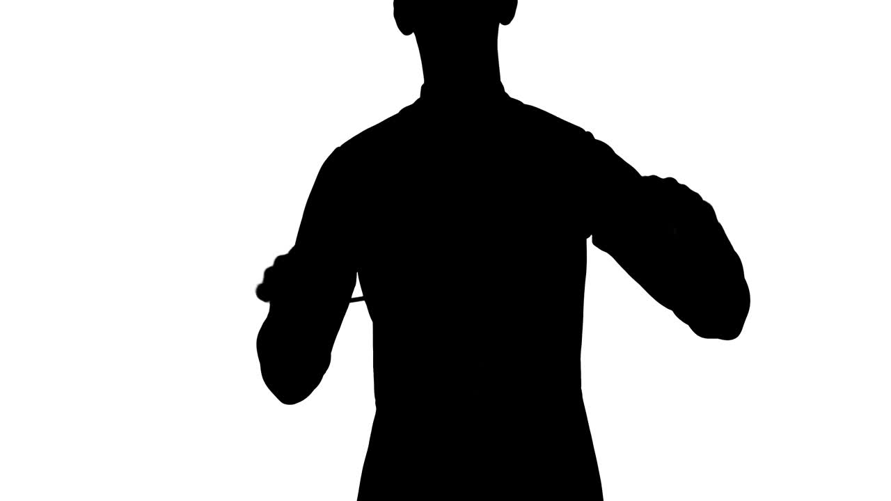 오케스트라 지휘자의 검은 실루은 하 스튜디오 배경에서 음악가들을 지휘하고, 동기화하고, 지휘하기 위해 지이를 흔들고 있습니다.