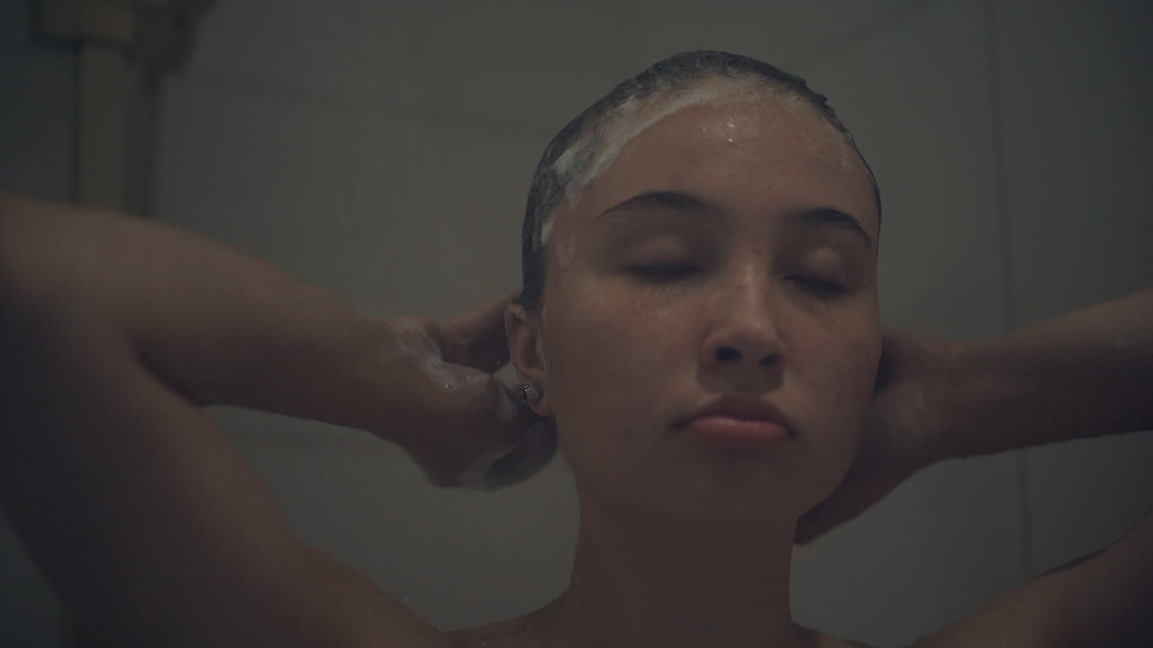 mujer lavándose el cabello en la ducha