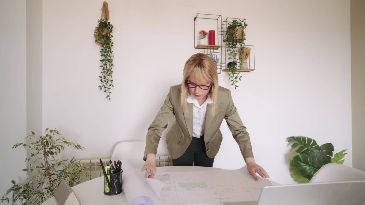 Woman reviewing blueprints at a table