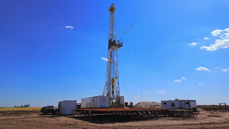 approaching the little site for drilling natural resources in the desert. borer at the derrick works producing oil. low angle view.