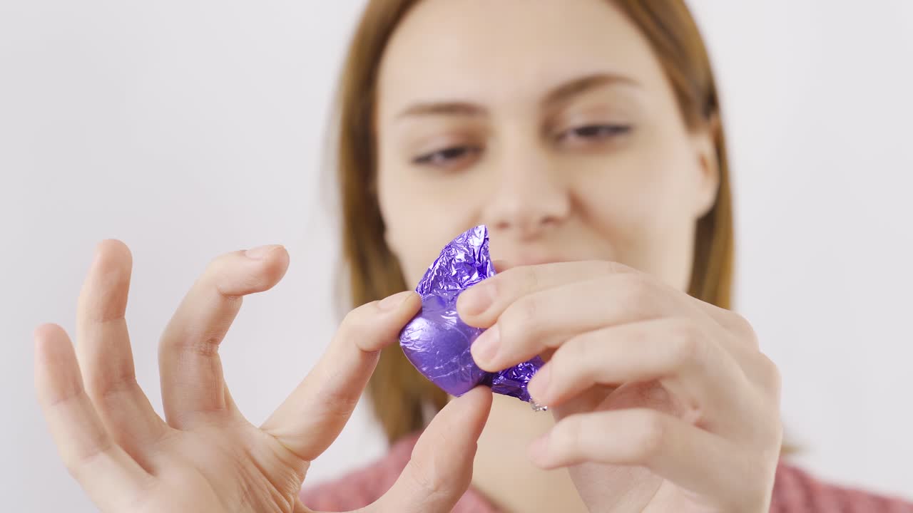 mujer comiendo chocolate con el corazón en primer plano. comiendo chocolate.