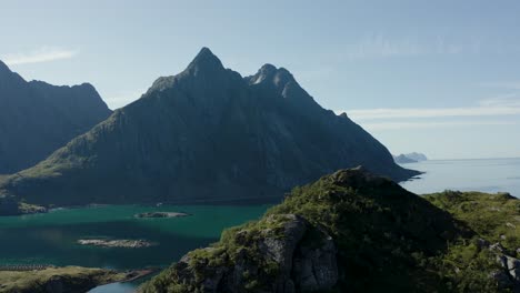 Toma-Aérea-De-Un-Paisaje-Escandinavo-Con-Espectaculares-Montañas,-Océano-Y-Vegetación-Verde