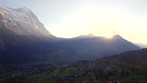 aerial drone footage dolly left to right of grindelwald village with stunning view of eiger north face at sunset