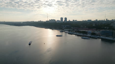 aerial view of city river and skyline at sunrise or sunset with boats