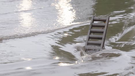 Floodwaters quickly flow into a recently cleared storm drain as cars slowly drive past