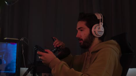 male gaming with a game pad and talking into and moving a microphone while streaming