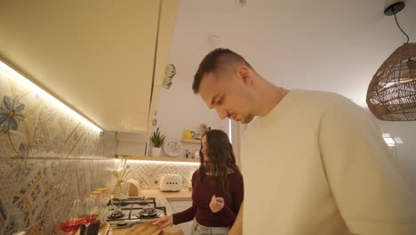 una pareja enamorada haciendo un sándwich en la cocina de la sala de estar