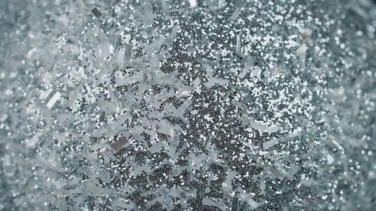 Gnistrande silverglitter och konfettibakgrund.