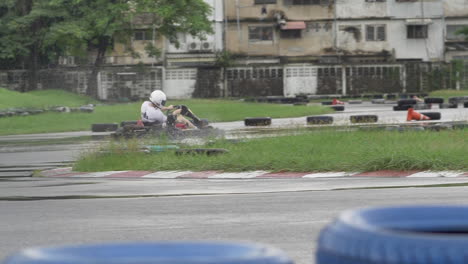 person driving a go-kart on a wet track