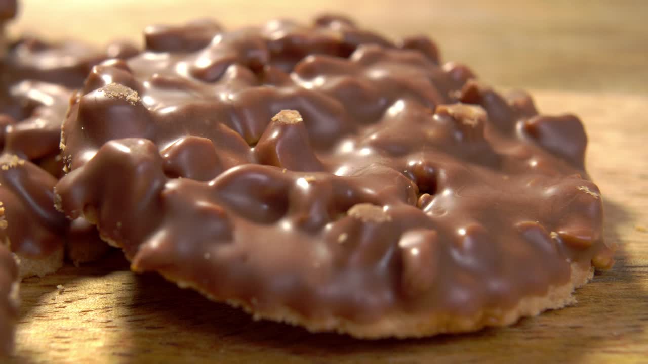 우유 초콜릿으로 인 걱거리는 비스. 시골 목조 표면에 땅콩이 있는 비스