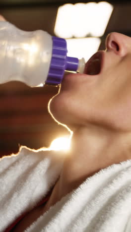 female boxer drinking water in boxing ring