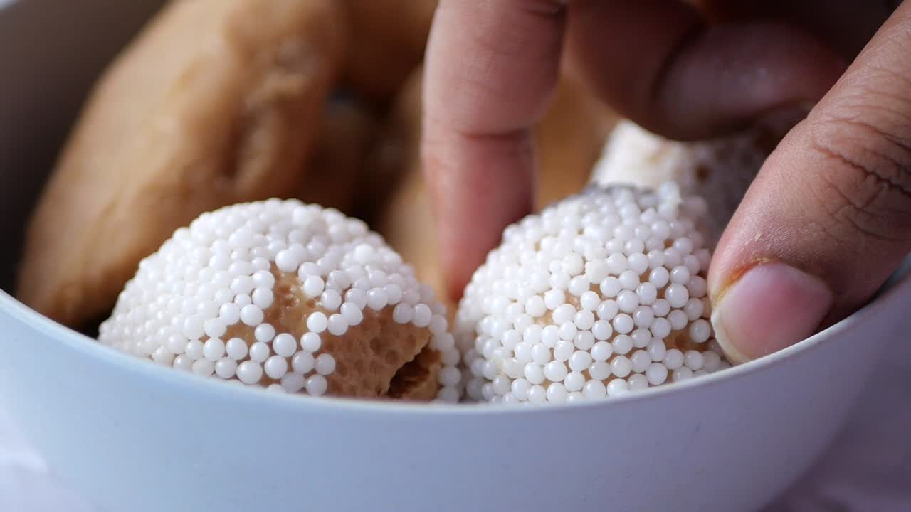 la mano agarrando una galleta azucarada de un cuenco