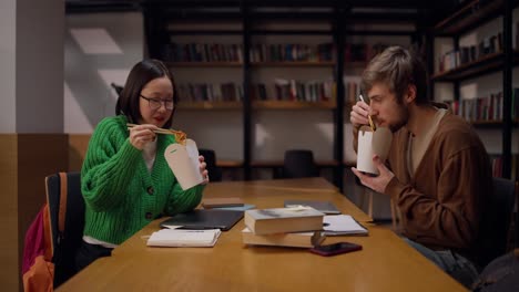 estudiantes comiendo almuerzo en una biblioteca