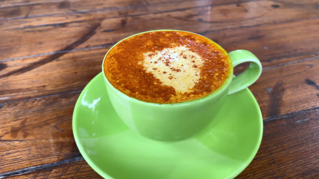 코코넛 밀크와 계피 가루를 얹은 강황 라떼