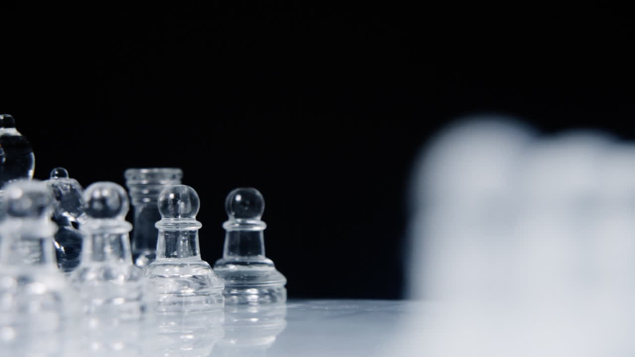 두 개의 다른 전체 세트의 유리 조각이 천천히 회전하고 다른 쪽을 흐릿한 라인업으로 드러내는 멋진 체스 보드