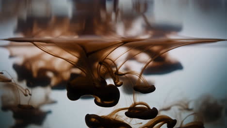 brown ink diffusing in water with organic swirling shapes