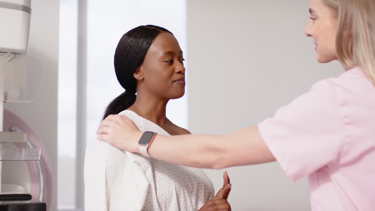 Patient and tech speaking after tech reaching in, adjusting gown for imaging device, copy space