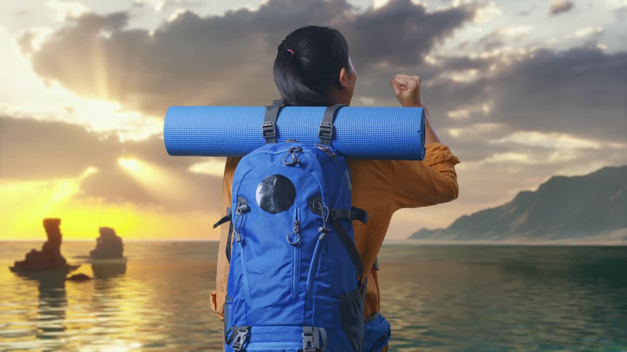 Back View Of A Female Hiker With Mountaineering Backpack Screaming Goal Celebrating The Success While Standing on Beach During Sunset Time
