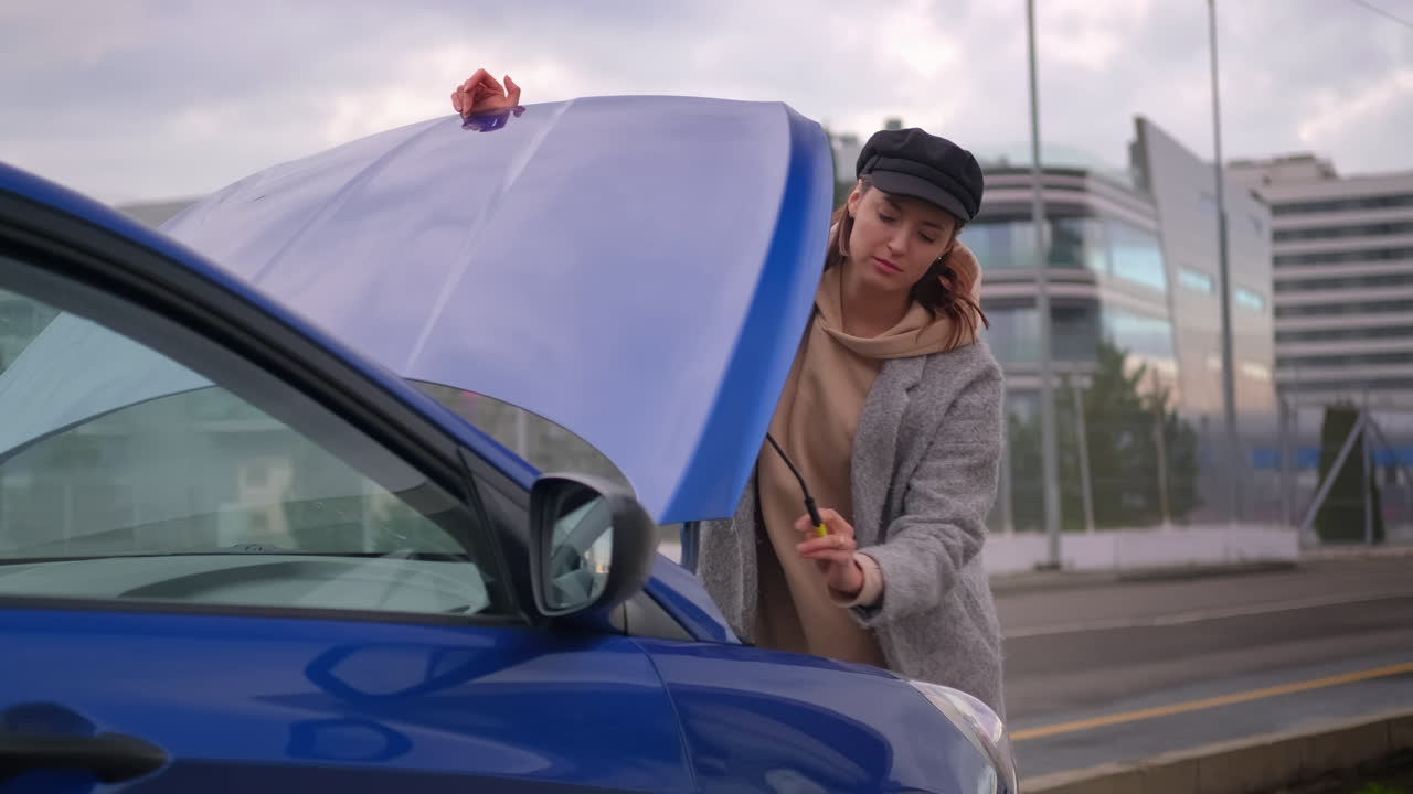 여자 가 도로  에 부러진 차 를 고치고 있다