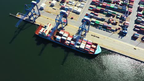 Container-ship-in-import-export-and-business-logistic,-By-crane,-Trade-Port,-Shipping-cargo-to-harbor,-Aerial-view-from-drone,-International-transportation,-Business-logistics-concept