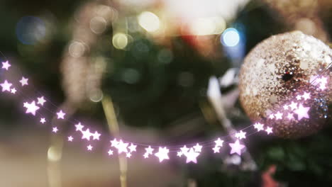 animation of star string lights and blurred christmas tree decorations