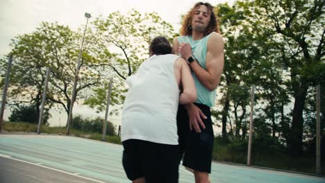 A-red-haired-man-in-a-gray-T-shirt-dribbles-a-basketball-and-brilliantly-throws-it-into-the-hoop.-He-his-team-rejoices-in-victory