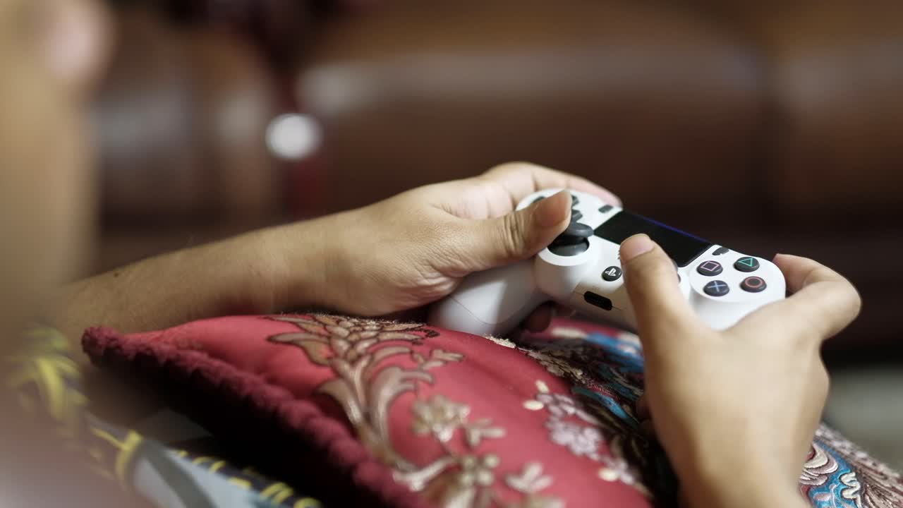 ps4 컨트롤러로 비디오 게임을 하는 사람