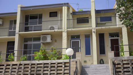 concrete stairs steps up to entry way of cream yellow apartment complex