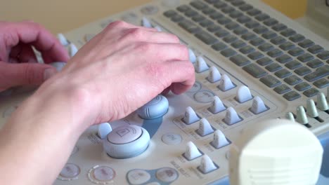close up of hands of young doctor working on ultrasound device