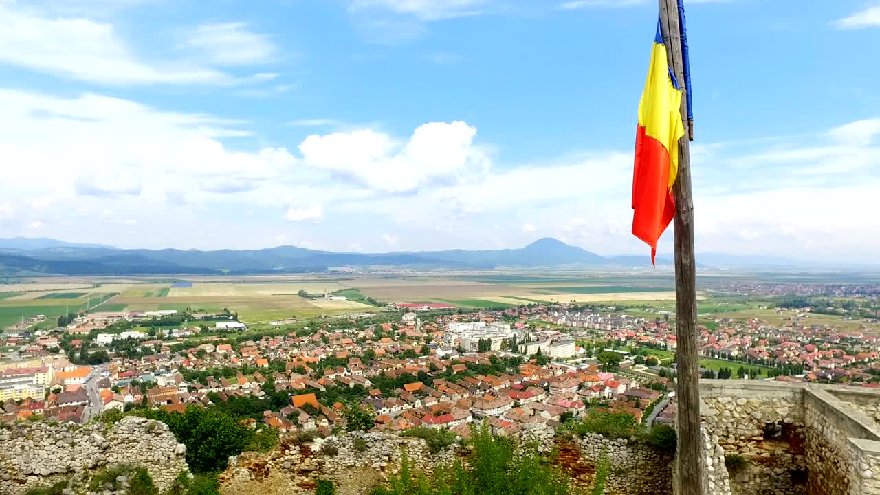 Bandiera rumena con la città di Râșnov sullo sfondo.