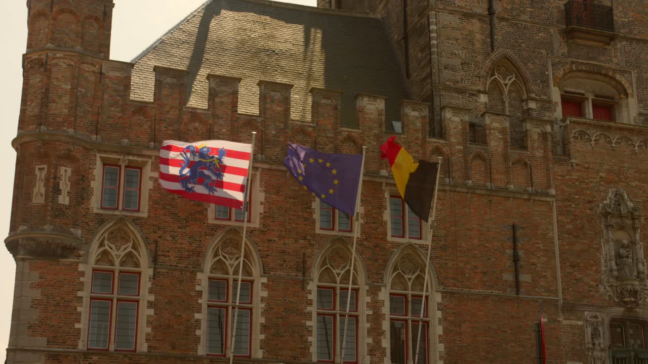 banderas que vuelan sobre el campanario de bruges, bélgica