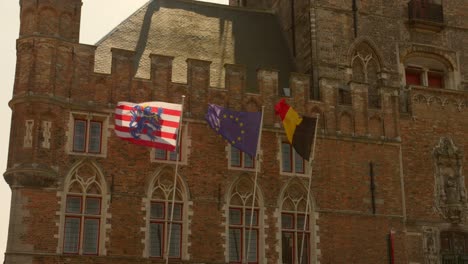 Banderas-Ondeando-Sobre-El-Campanario-De-Brujas,-Bélgica