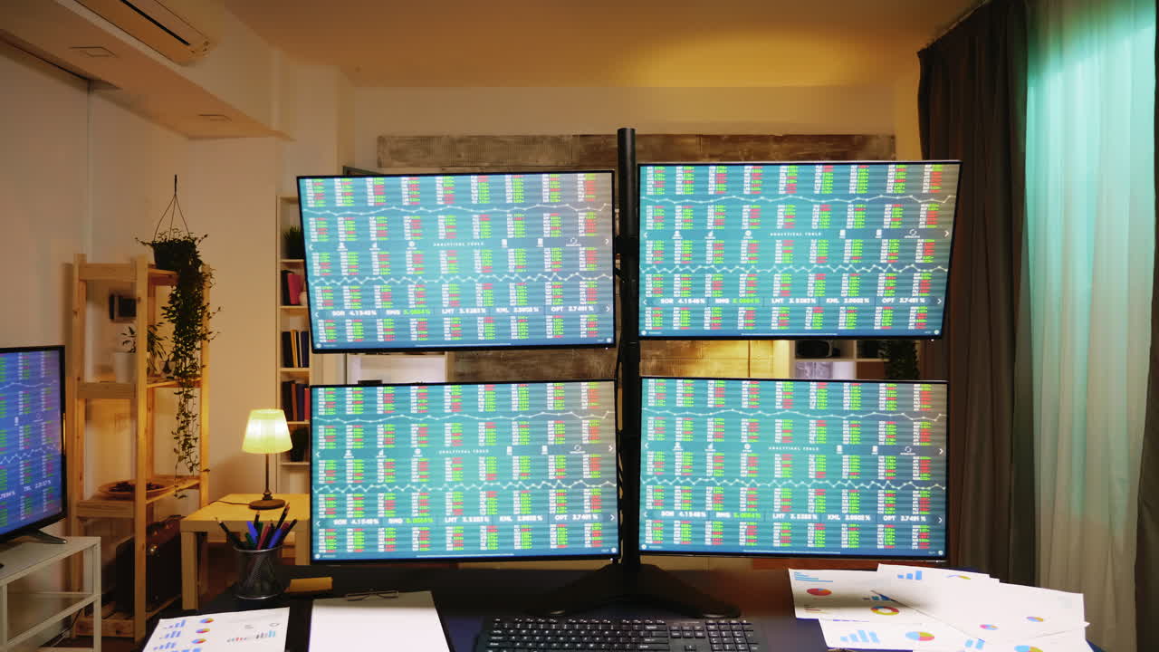 Four displays showing stock market graphs