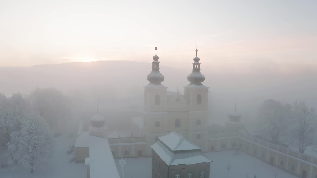 Christian monastery on top of the hill in fog in winter from drone